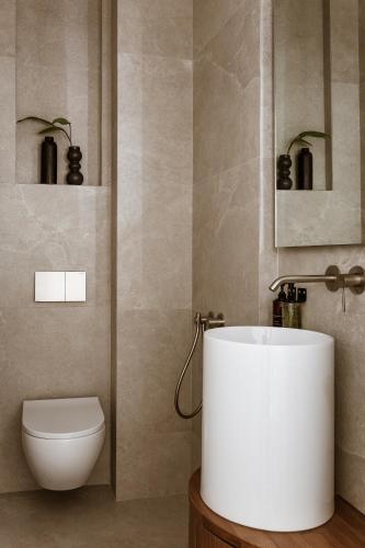 a bathroom with a white tub and a toilet at Likno Athens in Athens