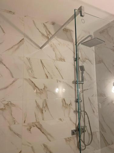 a bathroom with a shower with white marble walls at Apartments in Vienna suburbs - 40 min from Vienna city center 