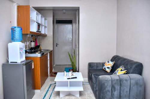 a living room with a couch and a table at Elegant Studio with Rooftop Pool in Nairobi -Jovial Homes in Kiambu