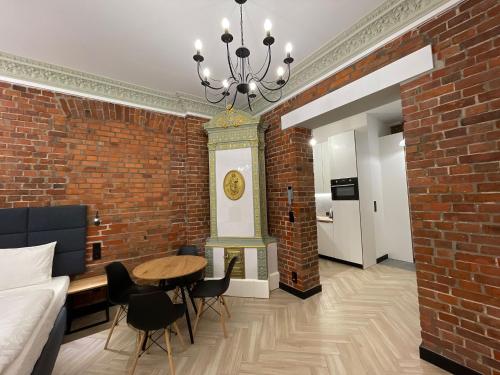 a room with a brick wall and a table and chairs at Pod Błękitnymi Podkowami in Wrocław
