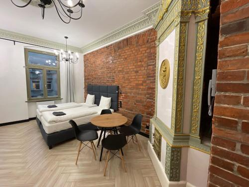 a bedroom with a bed and a table and chairs at Pod Błękitnymi Podkowami in Wrocław