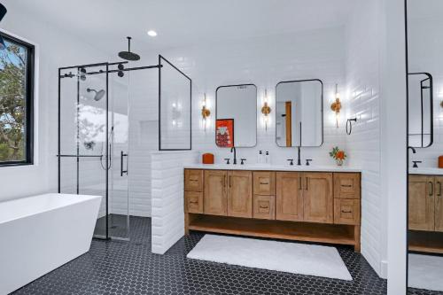 bagno con vasca, lavandino e specchi di Pasatiempos a Wimberley