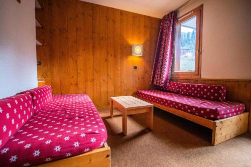 une chambre avec deux canapés rouges et une fenêtre dans l'établissement Résidence Pierres Plates G - PIERRES PLATES 31 MAE-1921, à Valmorel