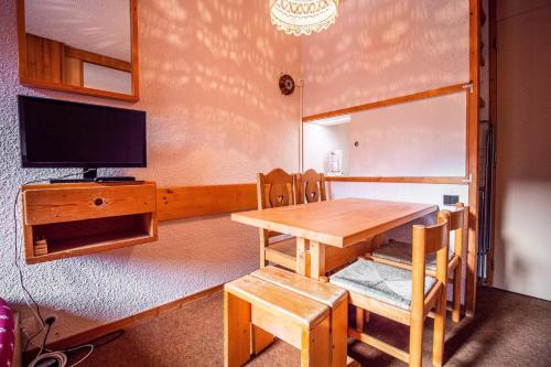 une salle à manger avec une table et une télévision dans l'établissement Résidence Pierres Plates G - PIERRES PLATES 31 MAE-1921, à Valmorel