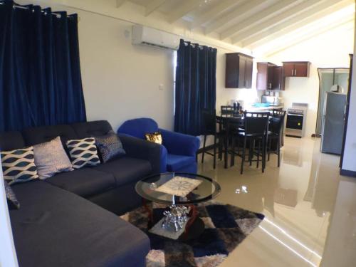 a living room with a couch and a table at Harbour Oasis Retreat - Charming 2 Bedroom House in Old Harbour