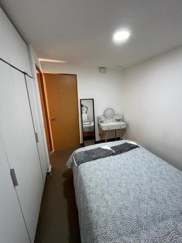 a bedroom with a bed and a table in it at Súperanfitrión Coyoacán El Alebrije in Mexico City