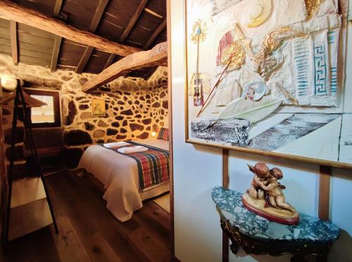 a room with a bed and a picture of a bedroom at Castrum Houses - Casa da Curveirinha - Jacuzzi in Melgaço