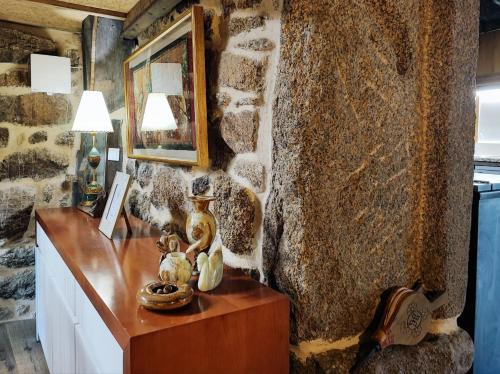 a room with a table and a stone wall at Castrum Houses - Casa da Curveirinha - Jacuzzi in Melgaço