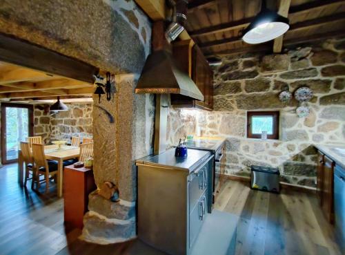 a kitchen with a stove top oven in a room at Castrum Houses - Casa da Curveirinha - Jacuzzi in Melgaço