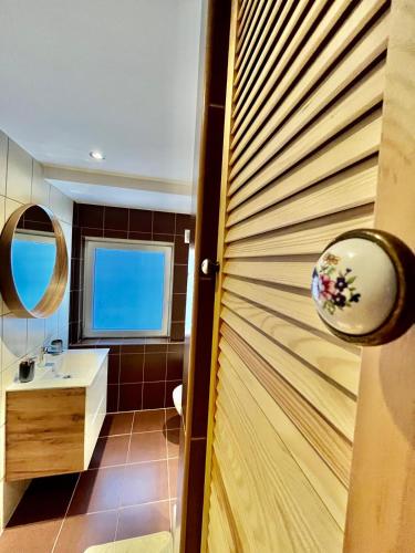 a bathroom with a wooden door and a sink at W parku przy teatrze in Szczawno-Zdrój