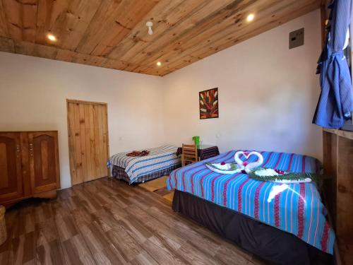 a bedroom with two beds and a wooden floor at Eco-Hotel Mayachik in San Juan La Laguna
