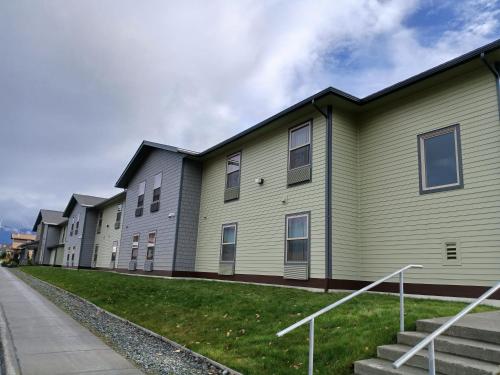 a row of buildings with stairs next to a sidewalk at Aspen Suites Hotel Haines in Haines