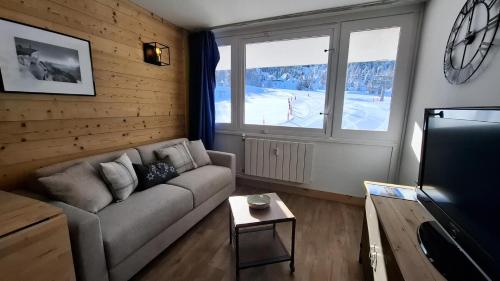 un salon avec un canapé et une télévision dans l'établissement Résidence Le France - Joli studio moderne MAE-9001, à Aime La Plagne