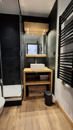 une salle de bain avec un lavabo et un miroir dans l'établissement Résidence Le France - Joli studio moderne MAE-9001, à Aime La Plagne