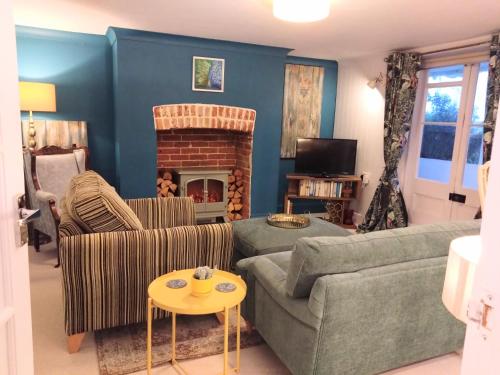 a living room with a couch and a fireplace at Beachfront Studio Apartment in Felixstowe
