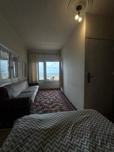 a bedroom with a bed and a couch and a window at Haidar Private bedroom for Men only غرف خاصه للرجال فقط 仅限男性 in Alexandria