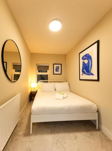 a bedroom with a bed and a mirror at The Annadale - Luxury 3 bd House - Gold Short Term Stays in Belfast