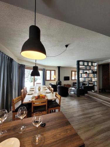 - une salle à manger et un salon avec une table et des verres à vin dans l'établissement Chalet Le Replan - Confort, lumière et nature à deux pas des pistes MAE-0841, aux Gets