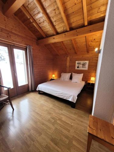 une chambre avec un lit dans une pièce avec des plafonds en bois dans l'établissement Chalet Le Replan - Confort, lumière et nature à deux pas des pistes MAE-0841, aux Gets