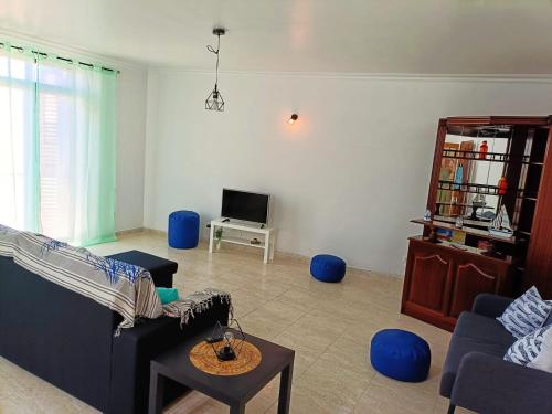 a living room with a couch and a tv at Casa Besugo in Sesimbra