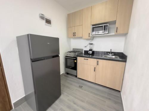 a kitchen with a stainless steel refrigerator and a sink at La Yarolina in Punta Cana