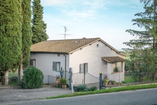 a white house with a fence and trees at Agriturismo Terre di Anghiari in Anghiari