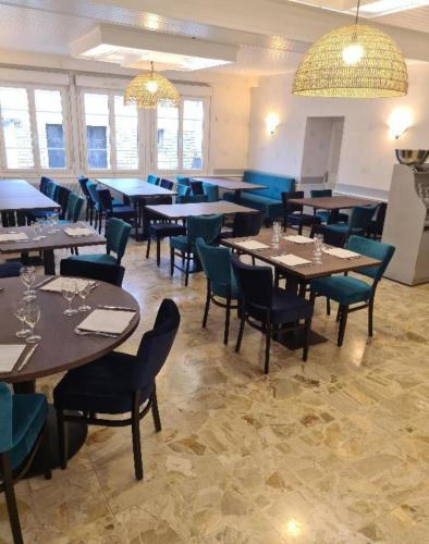 une salle à manger avec des tables, des chaises et des lumières dans l'établissement Auberge de Lanouaille, à Lanouaille
