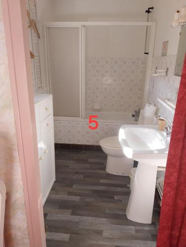 une salle de bain avec des toilettes blanches et un lavabo dans l'établissement Auberge de Lanouaille, à Lanouaille