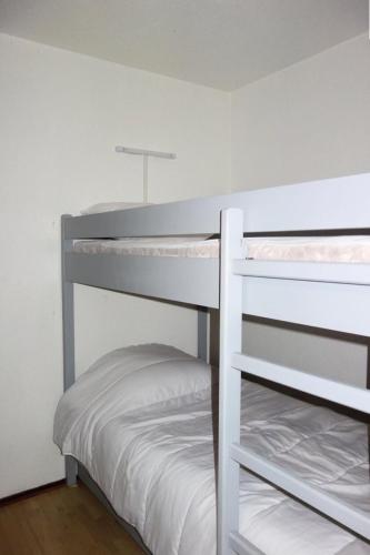 Ce lit se trouve dans un dortoir blanc doté de 2 lits superposés. dans l'établissement Résidence Portes D'huez - APPARTEMENT ALPE DHUEZ QUARTIER PASSEAUX MAE-9311, à Huez