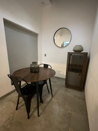 a table and chairs in a room with a mirror at La Casa Mia Leon in León