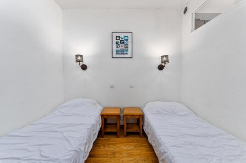 Cette chambre comprend 2 lits, une table et des lumières. dans l'établissement Résidence Les Hauts De Preclaux - Appartement avec terrasse donnant sur les pistes MAE-0861, aux Orres