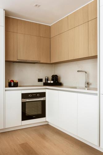 a kitchen with white cabinets and a sink at Likno Athens in Athens