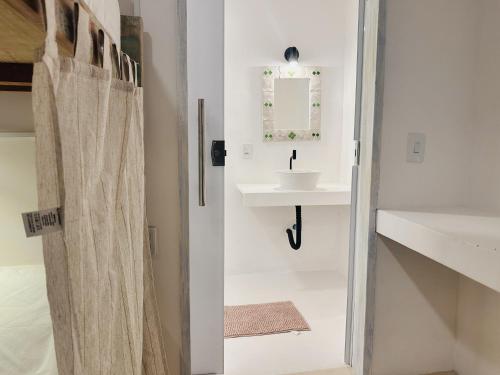 a bathroom with a sink and a shower curtain at Pousada Vilab in Arraial d'Ajuda
