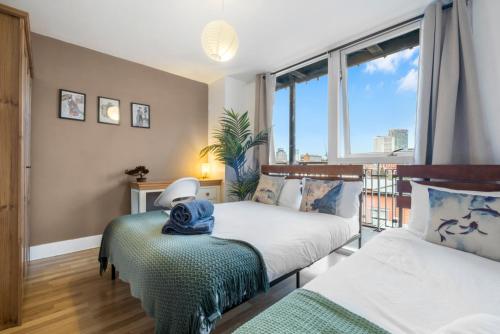 a bedroom with two beds and a large window at Asian Suite- Balcony - Nexflix and FREEPark in Birmingham