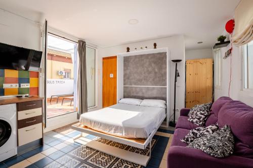 a bedroom with a bed and a purple couch at Ático la Azotea con terraza PRIVADA in Seville
