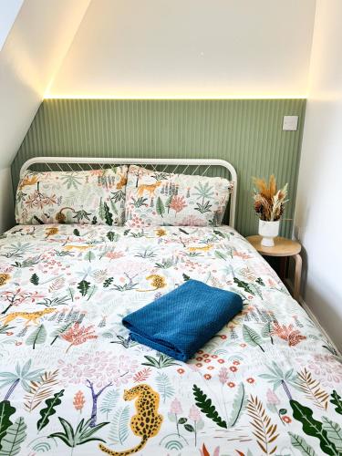 a bed with a blue pillow on top of it at GRANBY APARTMENTS F-3 in Leicester