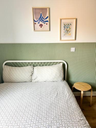 a bedroom with a bed with a green striped wall at GRANBY APARTMENTS F-3 in Leicester