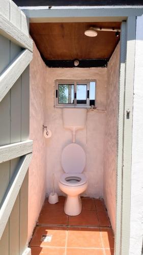 aseo en un baño pequeño con ventana en El Bonito Hostel, en Cabo Polonio