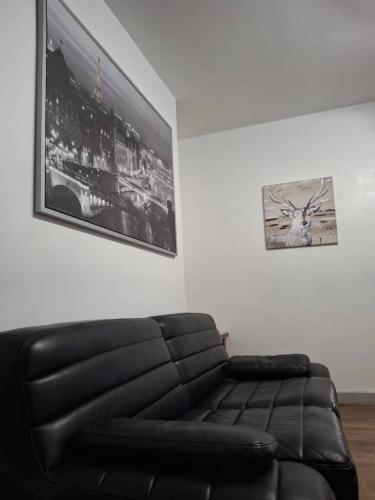 a black leather couch in a living room with a picture at Kilvington Crib in Sheffield