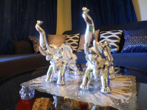 two glass giraffes on a table in a living room at Harbour Oasis Retreat - Charming 2 Bedroom House in Old Harbour