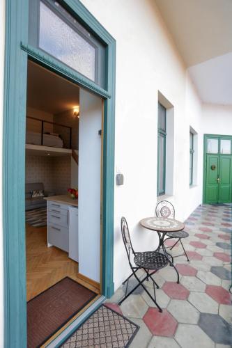 a room with a table and a chair and a kitchen at Ferdinand by NUX in Cluj-Napoca