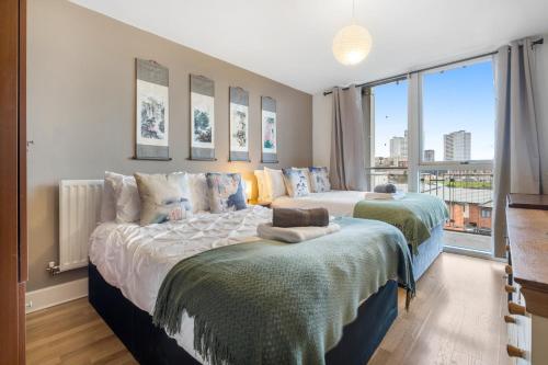 a bedroom with two beds and a large window at Asian Suite- Balcony - Nexflix and FREEPark in Birmingham