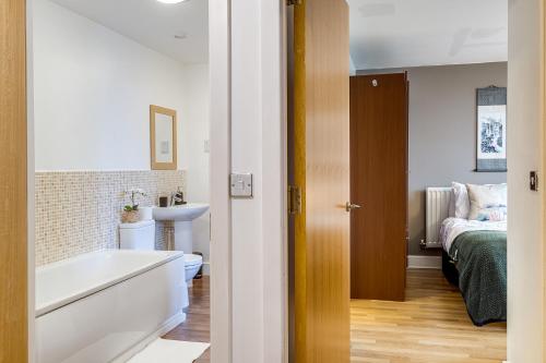 a bathroom with a tub and a sink and a bed at Asian Suite- Balcony - Nexflix and FREEPark in Birmingham