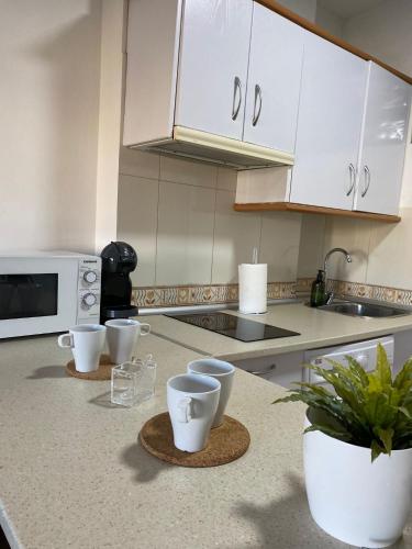 a kitchen with white cabinets and a counter top at Playa y paz in Benalmádena