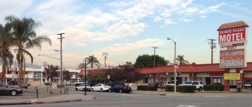 a motel with cars parked in a parking lot at Eunice Plaza Motel in El Monte