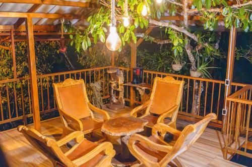 a group of chairs and a table on a porch at Riverside La Masía Ecohotel in Quindío