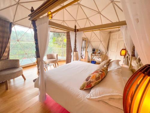a bedroom with a canopy bed with a large window at Riverside La Masía Ecohotel in Quindío