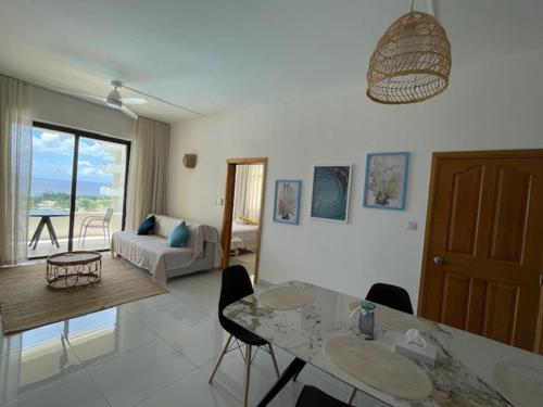 a kitchen and living room with a table and chairs at Sunset Ocean View Apartment in Flic-en-Flac