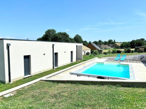 une maison blanche avec une piscine dans la cour dans l'établissement Maison contemporaine, à Soizy-aux-Bois
