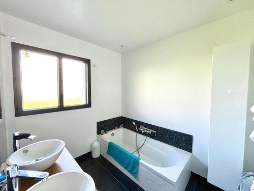 une salle de bain avec une baignoire et un lavabo dans l'établissement Maison contemporaine, à Soizy-aux-Bois